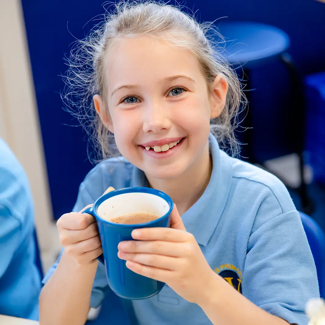 Girl holding mug of hot chocolate and smiling